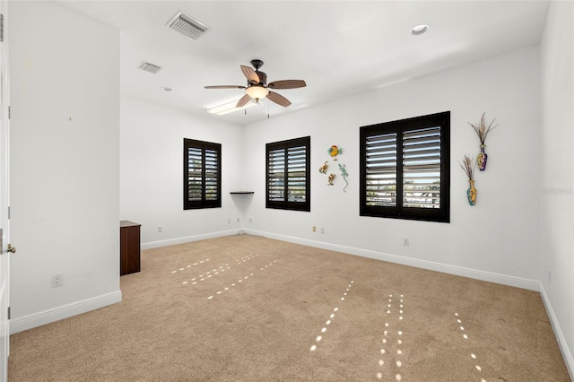 carpeted spare room featuring ceiling fan