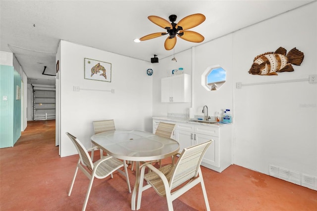 dining area with ceiling fan and sink