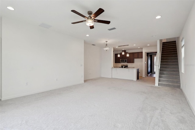 unfurnished living room with light colored carpet and ceiling fan