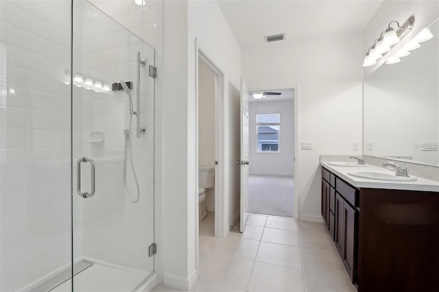 bathroom featuring tile patterned floors, toilet, an enclosed shower, and vanity