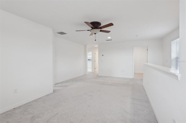 spare room with light colored carpet and ceiling fan