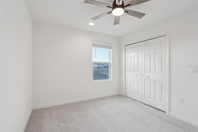 unfurnished bedroom featuring light carpet, ceiling fan, and a closet