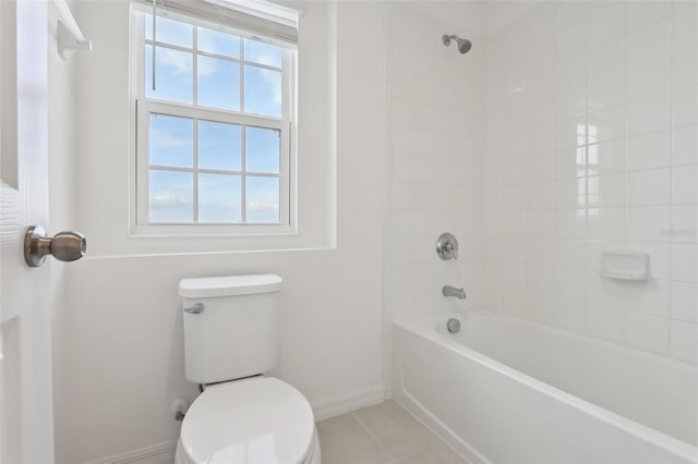 bathroom featuring tiled shower / bath, tile patterned floors, and toilet