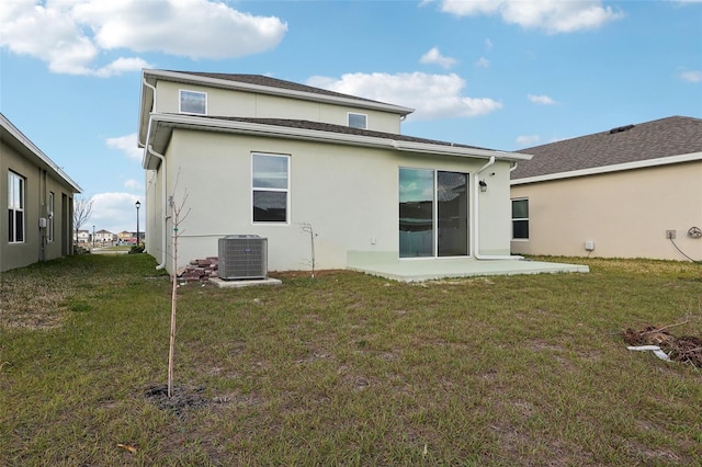 rear view of house featuring a patio, a yard, and central AC unit