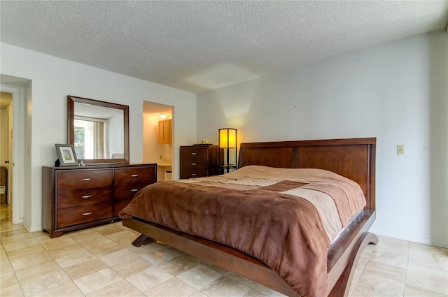 bedroom featuring ensuite bath and a textured ceiling