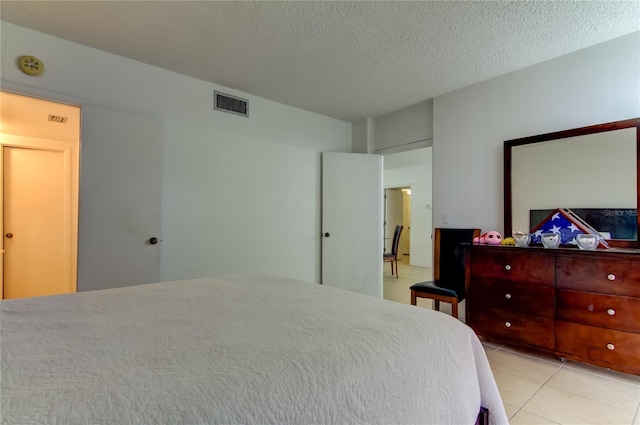 tiled bedroom featuring a textured ceiling