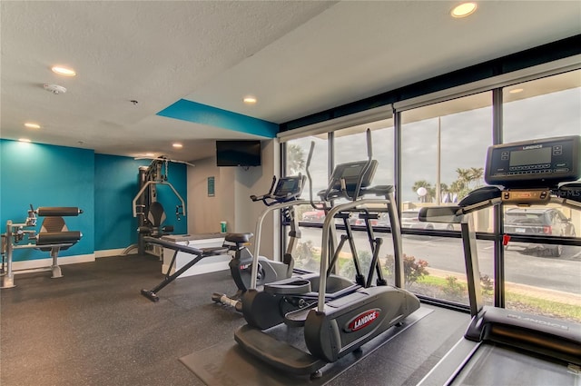 exercise room featuring a healthy amount of sunlight and a textured ceiling