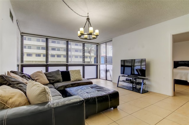 5396 Gulf Blvd Unit 110, St Pete Beach, FL 33706 - living area featuring floor to ceiling windows, light tile patterned floors, a chandelier, and a textured ceiling