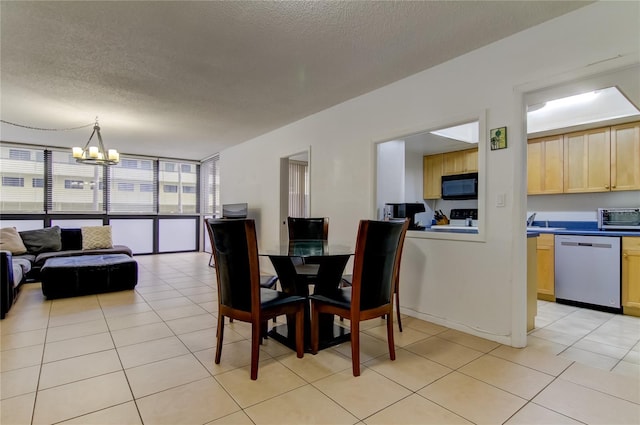 5396 Gulf Blvd Unit 110, St Pete Beach, FL 33706 - dining area featuring a textured ceiling, a chandelier, and light tile patterned flooring