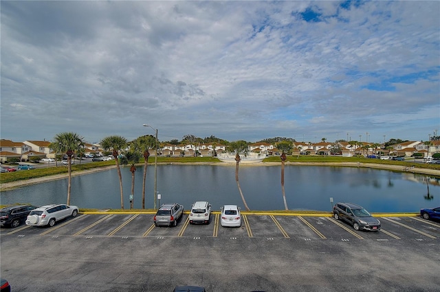 uncovered parking lot featuring a residential view and a water view