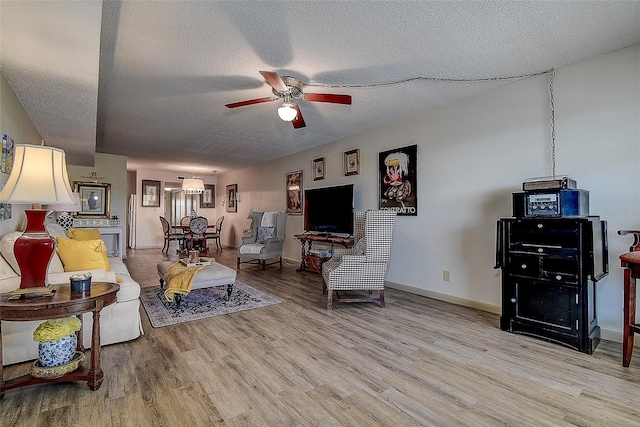 6400 46th Ave N Unit 307, Kenneth City, FL 33709 - living area featuring a ceiling fan, light wood-style floors, and a textured ceiling