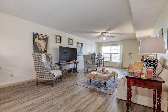6400 46th Ave N Unit 307, Kenneth City, FL 33709 - living room with wood finished floors, a ceiling fan, and a textured ceiling