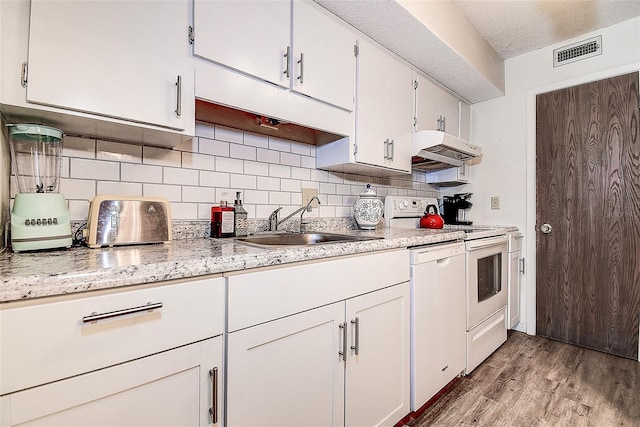 6400 46th Ave N Unit 307, Kenneth City, FL 33709 - kitchen with range, under cabinet range hood, dishwasher, tasteful backsplash, and light wood-style flooring