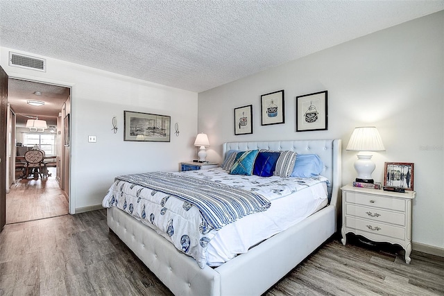 6400 46th Ave N Unit 307, Kenneth City, FL 33709 - bedroom featuring wood finished floors and a textured ceiling