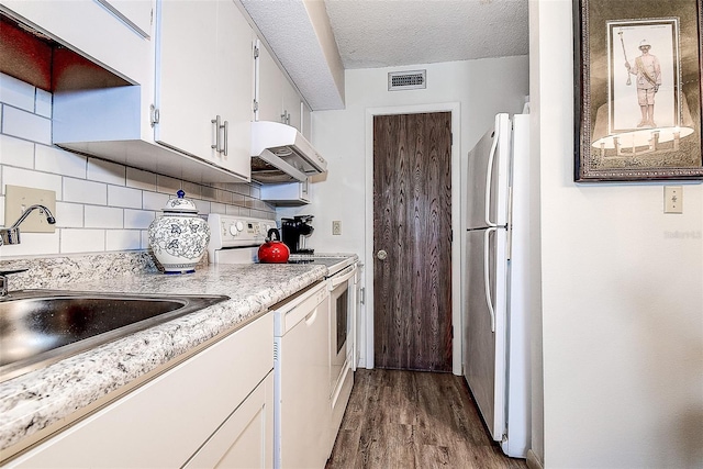 6400 46th Ave N Unit 307, Kenneth City, FL 33709 - kitchen with white appliances, under cabinet range hood, wood finished floors, light countertops, and backsplash
