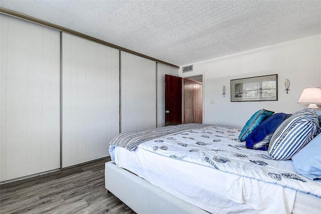 6400 46th Ave N Unit 307, Kenneth City, FL 33709 - bedroom featuring wood finished floors, a textured ceiling, and a closet