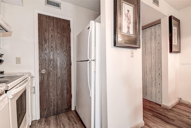 6400 46th Ave N Unit 307, Kenneth City, FL 33709 - kitchen with white appliances, wood finished floors, a textured ceiling, light countertops, and range hood