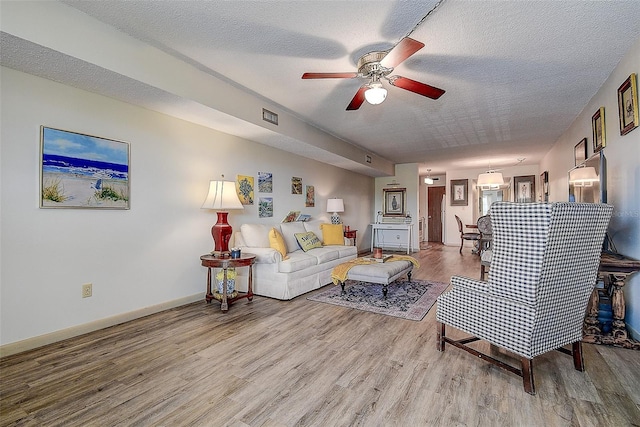 6400 46th Ave N Unit 307, Kenneth City, FL 33709 - living area with ceiling fan, wood finished floors, and a textured ceiling