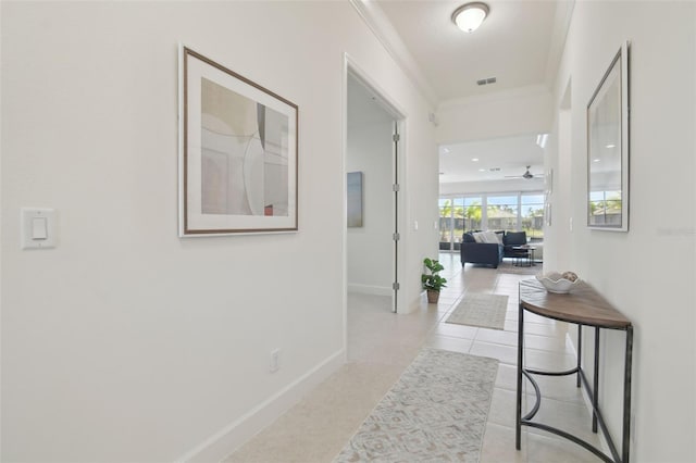 hall featuring crown molding and light tile patterned flooring