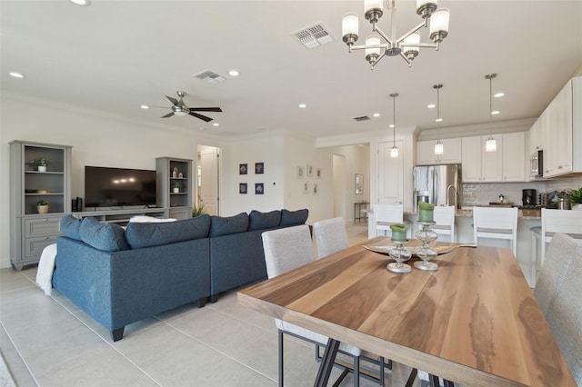 tiled dining room with crown molding and ceiling fan with notable chandelier