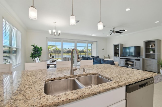 kitchen with sink, decorative light fixtures, light stone countertops, and dishwasher