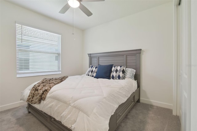 bedroom featuring light colored carpet, ceiling fan, and a closet