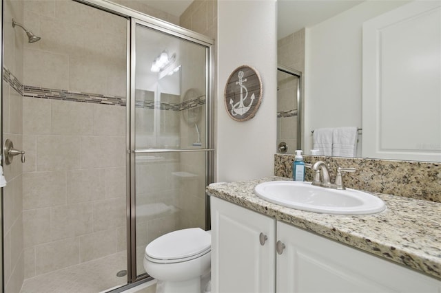 bathroom with walk in shower, vanity, and toilet