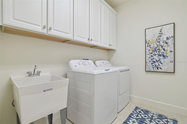 laundry area featuring washer and dryer, sink, and cabinets