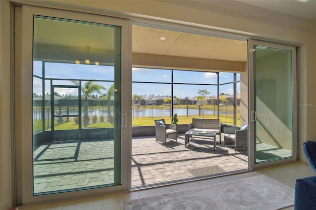 entryway featuring ornamental molding, tile patterned floors, and a water view