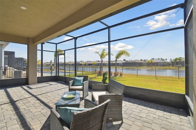 view of patio / terrace featuring a lanai, outdoor lounge area, and a water view