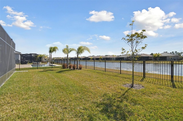 view of yard with a fenced in pool, a lanai, and a water view