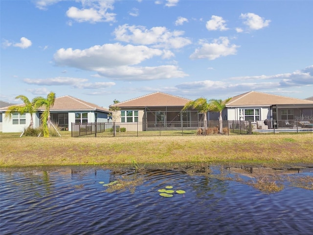 back of property featuring a water view and a lawn