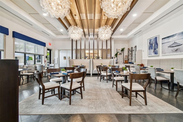 dining area with a towering ceiling, beamed ceiling, and a chandelier