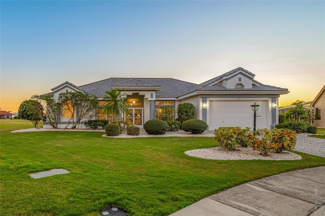 view of front facade featuring a garage and a lawn