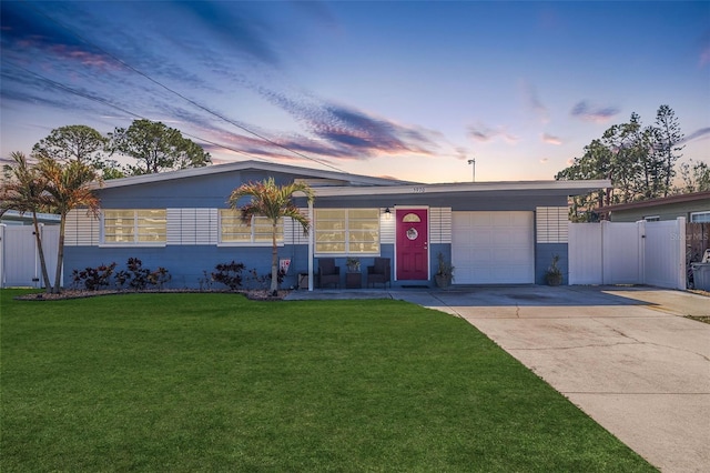 single story home featuring a yard and a garage