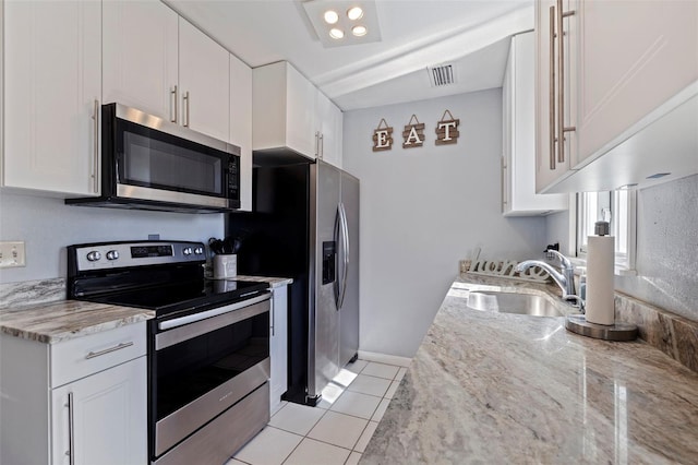 kitchen featuring appliances with stainless steel finishes, sink, white cabinets, and light stone counters