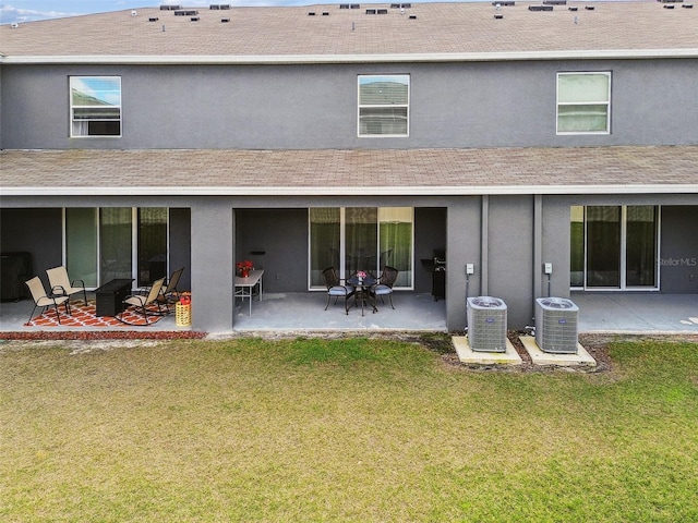 rear view of house featuring a yard, central AC, and a patio area