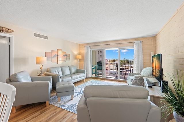 living room featuring a textured ceiling and light wood-type flooring