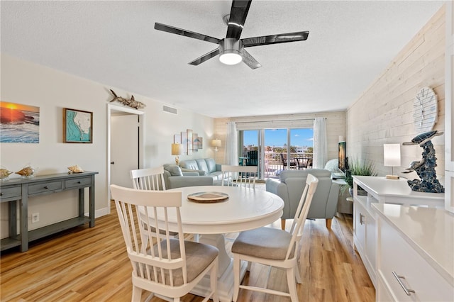 dining area featuring ceiling fan, light hardwood / wood-style flooring, and a textured ceiling