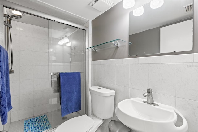 bathroom featuring an enclosed shower, sink, tile walls, and toilet