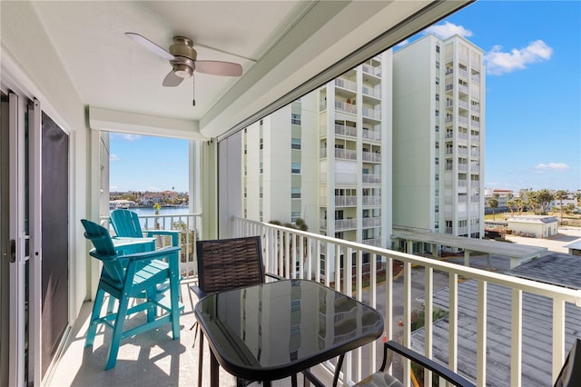 balcony featuring a water view and ceiling fan