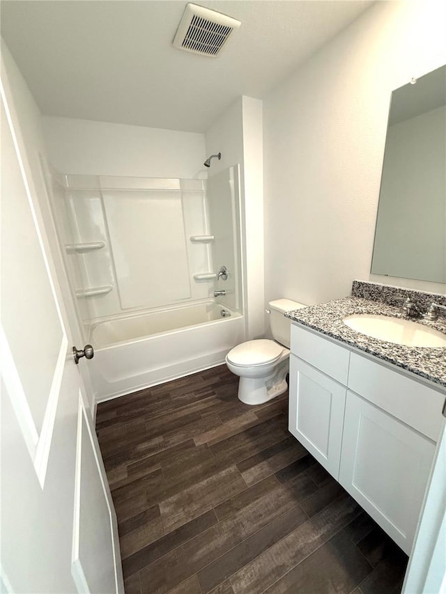 full bathroom with toilet, hardwood / wood-style floors, vanity, and  shower combination