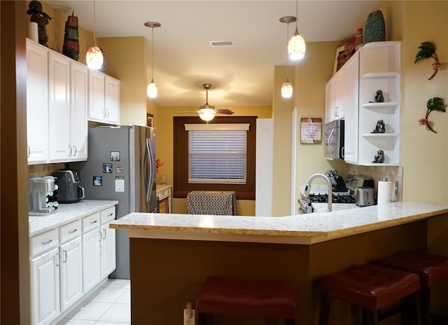 kitchen with white cabinetry, stainless steel appliances, a kitchen breakfast bar, and kitchen peninsula