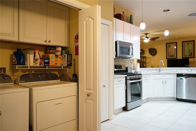 kitchen with sink, white cabinetry, pendant lighting, independent washer and dryer, and stainless steel appliances