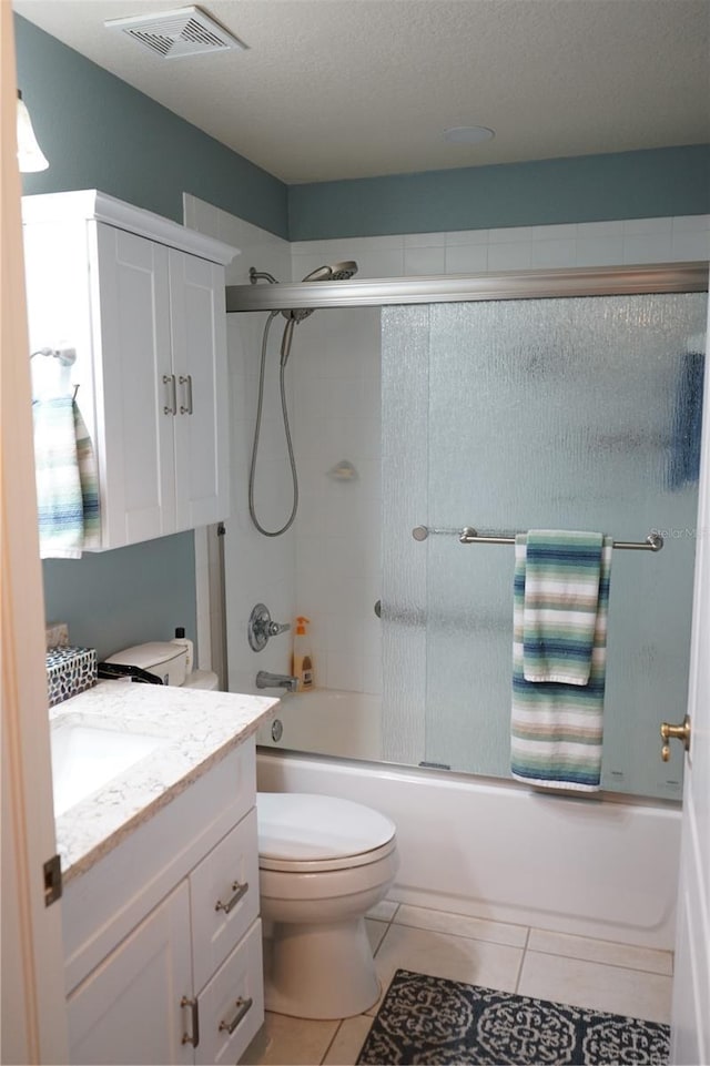 full bathroom featuring vanity, tile patterned floors, shower / bath combination with glass door, and toilet