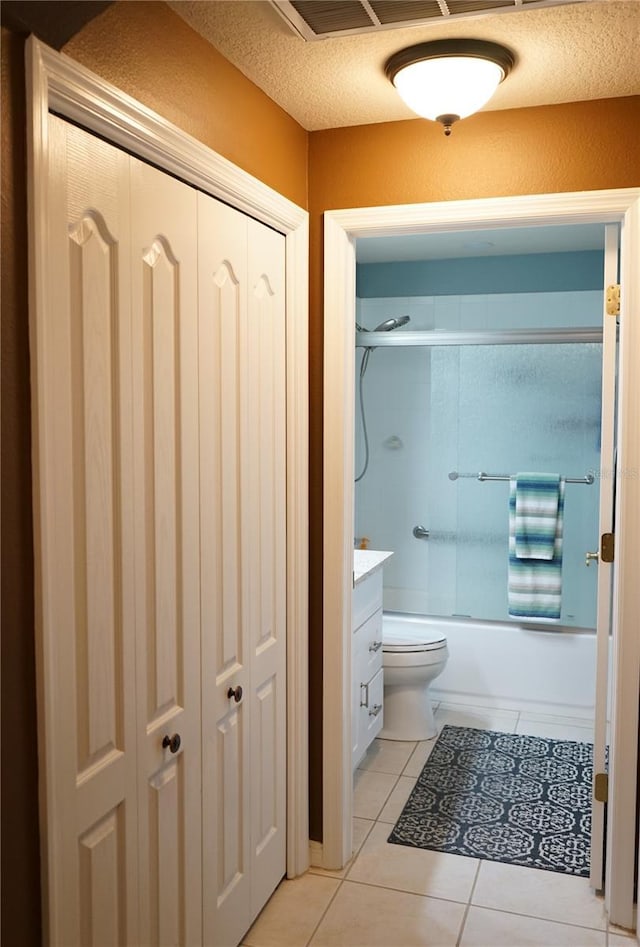 full bathroom with toilet, a textured ceiling, vanity, enclosed tub / shower combo, and tile patterned flooring