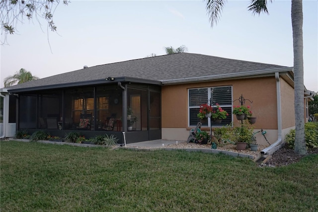 back of property featuring a yard and a sunroom