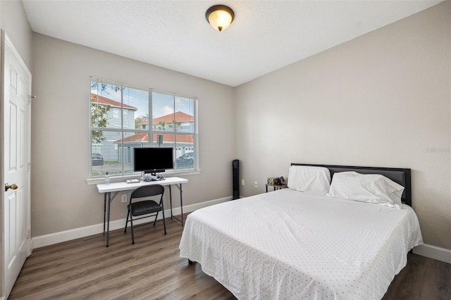 bedroom with wood finished floors and baseboards