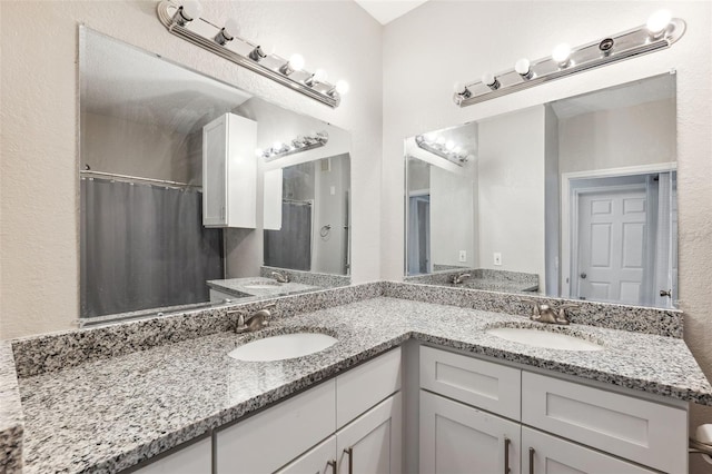 full bath featuring double vanity, a shower with shower curtain, and a sink