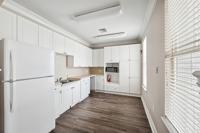 kitchen featuring visible vents, white cabinets, ornamental molding, dark wood-type flooring, and freestanding refrigerator